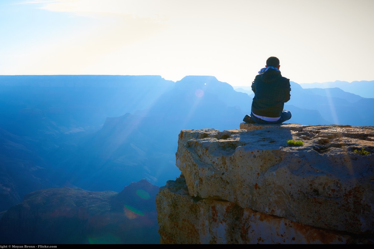 Leader meditating on a mountain top in the sun